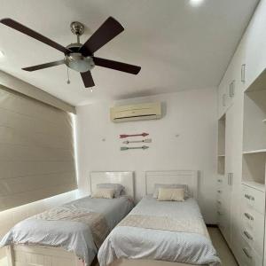 1 Schlafzimmer mit 2 Betten und einem Deckenventilator in der Unterkunft Condominio uaymitun,progreso in Uaymitun