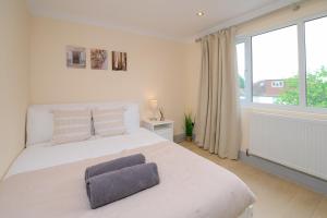a white bedroom with a large bed and a window at Stylish 4Bed 2 Bath, NW London Large Apartment in London