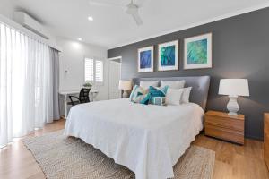 een slaapkamer met een groot bed met blauwe kussens bij Noosa Outrigger Beach Resort in Noosaville