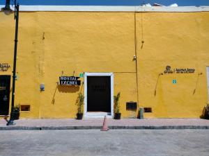 巴利亞多利德的住宿－Hostal Ixchel - WiFi, Hot Water, AC, in Valladolid Downtown，黄色的建筑,有门和标志