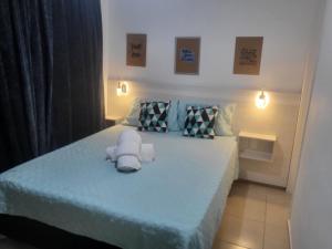 a bedroom with a teddy bear sitting on a bed at APTO ENCANTADOR, PISCINA, ACADEMIA E MUITO MAIS. in Campo Grande