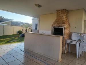 a outdoor kitchen with a brick fireplace in a house at APTO ENCANTADOR, PISCINA, ACADEMIA E MUITO MAIS. in Campo Grande