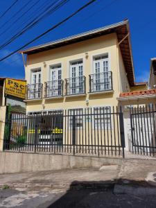 uma casa amarela com uma cerca preta à frente. em Pousada Souza Castro em Ouro Preto