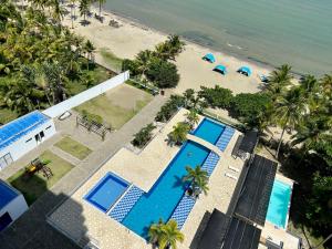 eine Luftansicht auf einen Strand mit zwei Swimmingpools in der Unterkunft Oceanview Apartment 3 bedrooms in Coveñas