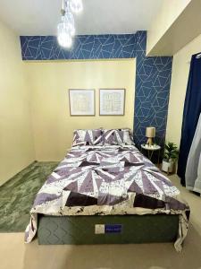 Bett in einem Schlafzimmer mit blauer Wand in der Unterkunft * *S Urban Dreamscape in Iloilo City