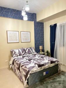 a bed in a bedroom with a blue wall at * *S Urban Dreamscape in Iloilo City