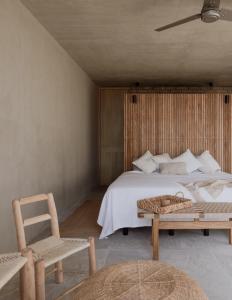 a bedroom with a bed and a chair and a table at Casa_Paki in Zihuatanejo
