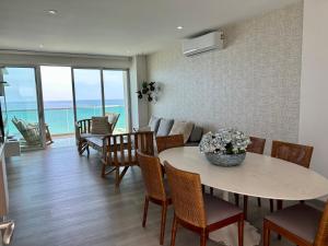 科韋尼亞斯的住宿－Oceanview Apartment 3 bedrooms，一间带桌椅和海洋的客厅
