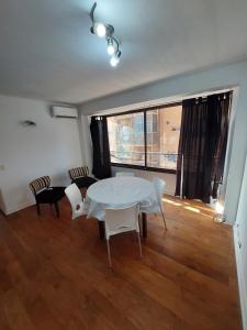 a white table and chairs in a room with a window at Departamento luminoso pleno centro calle España in Mendoza