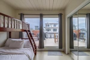 a bedroom with a bunk bed and a balcony at OceanCatcher - newly remodeled 3 bedroom retreat with ocean view in the heart of Mission Beach, sleeps 10 in San Diego