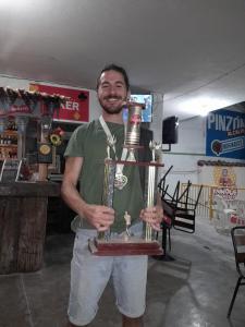 a man is holding a trophy in a store at ADVENTURE Hostel in San Gil