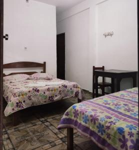 een slaapkamer met 2 bedden en een tafel en een tafel bij Pousada Estrada de Ferro in Tiradentes