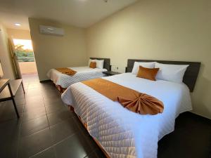Un pat sau paturi într-o cameră la LOS BAMBUES HOTEL
