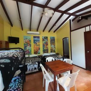 a room with beds and a table and chairs at Hotel Cabinas La Playa in Playa Avellana