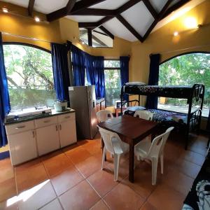 sala de estar con mesa, cocina y litera en Hotel Cabinas La Playa en Playa Avellana