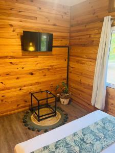 um quarto com uma parede de madeira e uma televisão em Bungalow KURA em Moorea