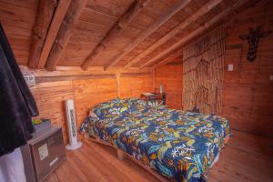 a bedroom with a bed in a wooden cabin at EVA Glamping in Santa Elena