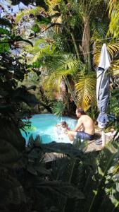 un hombre y una mujer en una piscina con una sombrilla en Pousada Villa da Nascente, en Florianópolis