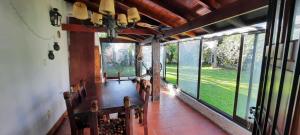 a dining room with a table and chairs and large windows at Chalet Playa Grande in Mar del Plata