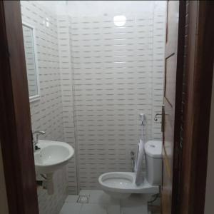 a white bathroom with a sink and a toilet at Bienveillance in Saint-Louis