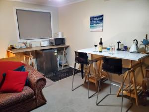 a living room with a tv and a table and a couch at Gateway to the Surf Coast and Geelong in Geelong