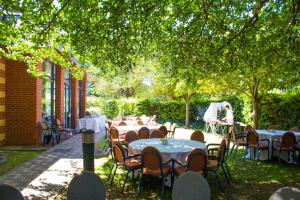 a group of tables and chairs under a tree at Millennium Hotel Paris Charles De Gaulle in Roissy-en-France