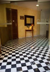 un suelo blanco y negro a cuadros en una habitación en Hotel Alfonso IX, en Cáceres