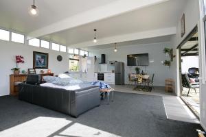a living room with a couch and a kitchen at Bella Park - New Plymouth Holiday Studio in New Plymouth