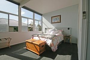 ニュープリマスにあるBella Park - New Plymouth Holiday Studioのベッドルーム1室(ベッド1台、大きな窓付)