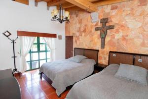 a bedroom with two beds and a cross on the wall at ¡Increíble casa en Avándaro para 10 personas! in Valle de Bravo