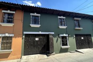 um edifício verde com um portão e janelas em Casa Colonial en casco Histórico em Comayagua