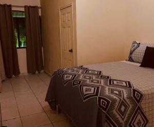 um quarto com uma cama com um cobertor preto e branco em Casa Colonial en casco Histórico em Comayagua