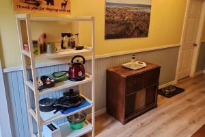 una cocina con estanterías blancas y un hervidor de agua. en cozy apartment near the ocean, en Guysborough