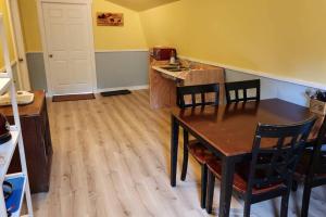 a kitchen with a table and chairs in a room at cozy apartment near the ocean in Guysborough