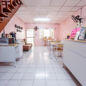 a kitchen with pink walls and white tile floors at Baan Mee Suk Ayutthaya in Phra Nakhon Si Ayutthaya