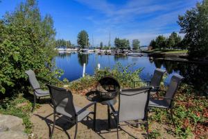 un grupo de sillas y una hoguera junto a un lago en La Perle Rose du Lac-St-Jean, en Roberval