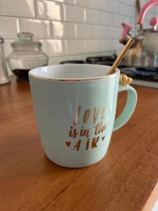 une tasse de café avec les mots que l'amour est dans la tasse dans l'établissement Las Piedritas Casa de Mar Loft, à Las Grutas