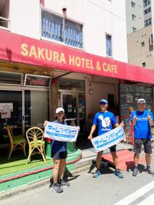 東京的住宿－神保町櫻花酒店，三名男子在旅馆前举着标牌