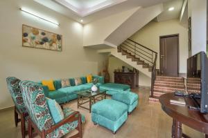 uma sala de estar com um sofá, cadeiras e uma mesa em Luxury 4BHK Villa with Private Pool Near Candolim em Marmagao