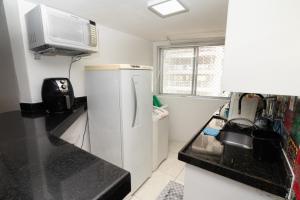 a kitchen with a white refrigerator and a microwave at Apt por temporada - Ponta Verde - De frente ao Caminho de Moises - 02 quartos in Maceió