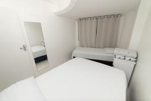 a small room with two beds and a mirror at Apt por temporada - Ponta Verde - De frente ao Caminho de Moises - 02 quartos in Maceió