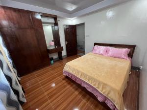 a bedroom with a bed with a pink pillow at Laguindingan Town House 