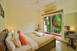 ein Schlafzimmer mit einem Bett und einem Balkon in der Unterkunft Luxury 4BHK Villa with Private Pool Near Candolim in Marmagao