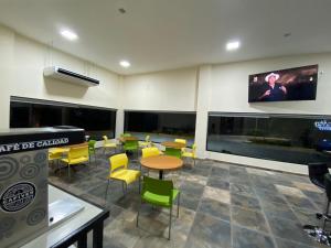a waiting room with tables and chairs and a flat screen tv at LOS BAMBUES HOTEL in La Tinaja