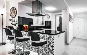 une cuisine avec un comptoir noir et des chaises noires dans l'établissement 2 Bedroom Cozy Apartment In Cala Bona, à Cala Bona