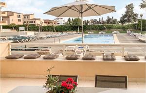 - une piscine avec des chaises et un parasol à côté d'une table dans l'établissement 2 Bedroom Cozy Apartment In Cala Bona, à Cala Bona 17 autres photos