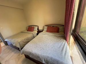 2 camas individuais num quarto com uma janela em Ground chlat first row lagoon 2 bedrooms at Blanca marassi em El Alamein
