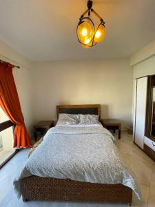 sypialnia z łóżkiem i żyrandolem w obiekcie Ground chlat first row lagoon 2 bedrooms at Blanca marassi w mieście El Alamein