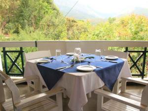 een tafel met een blauw tafelkleed op een balkon bij River Garden Resort in Belihul Oya