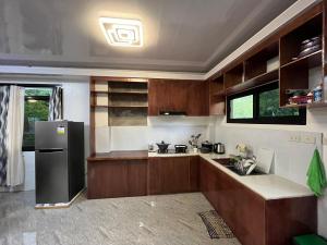 una cucina con armadi in legno e frigorifero nero di Laguindingan Town House a Laguindingan Altre 3 foto